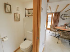 A bathroom with a toilet and wall art at Cedar Barn