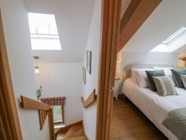 A bedroom with a bed and stairway at Cedar Barn 