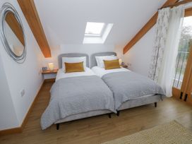 A bedroom with two beds and a window at Cedar Barn