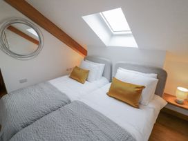 A bedroom with twin beds and a lamp at Cedar Barn