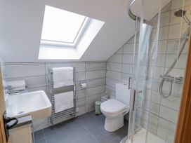 A bathroom with a shower, toilet, and sink at Cedar Barn