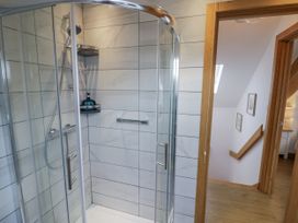 A shower with glass enclosure in a bathroom at Cedar Barn