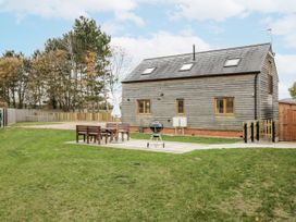 A garden with a wooden house and patio furniture at Cedar Barn