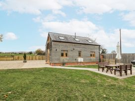 A house with a yard and patio furniture at Cedar Barn