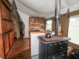 A kitchen with a wood stove and shelving at Pear Trees in Bewdley