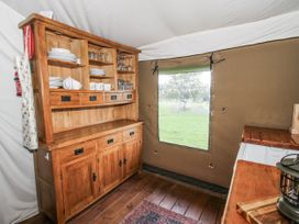 A kitchen with wooden cupboard and shelves at Pear Trees in Bewdley