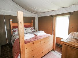 A bedroom with a wooden bed and table at Pear Trees Bewdley