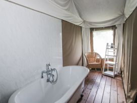 A bathroom with a bathtub and chair at Pear Trees Bewdley