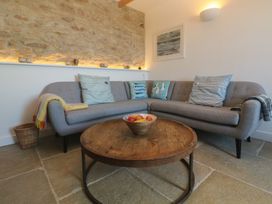 A living room with a sofa and a wooden table at 12 Boswedden Terrace St Just