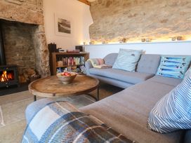 A living room with a sofa, coffee table, and fireplace at 12 Boswedden Terrace St Just