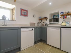 A kitchen with a sink, dishwasher, and microwave at 12 Boswedden Terrace in St Just