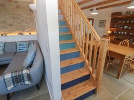 A living room with a staircase, sofa, and dining table at 12 Boswedden Terrace in St Just