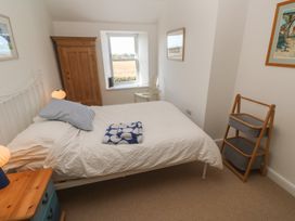 A bedroom with a bed and wardrobe at 12 Boswedden Terrace in St Just