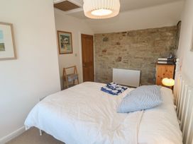 A bedroom with a bed and chair at 12 Boswedden Terrace St Just