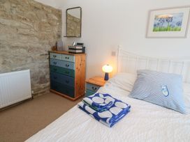 A bedroom with a bed and a dressing table at 12 Boswedden Terrace St Just