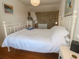 A bedroom with a bed, bedside lamp, and wardrobe at 12 Boswedden Terrace in St Just