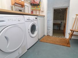 A laundry room with washing machines and a door at 12 Boswedden Terrace St Just