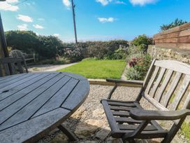 A garden with a wooden table and chair at 12 Boswedden Terrace St Just