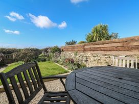 A garden with a wooden table and chairs at 12 Boswedden Terrace St Just