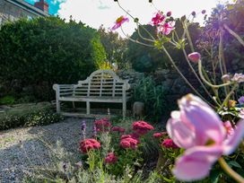 A garden with a bench and flowers at 12 Boswedden Terrace in St Just