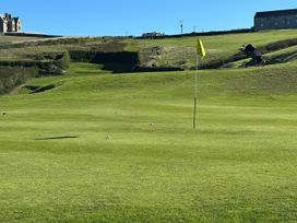 A golf course with a flag and balls at Sea Holly St Just