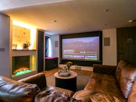 A living room with a projector screen and a fireplace at Manor Farm House in Merton near Bicester