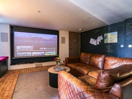 A snug with a projector screen and a sofa at Manor Farm House in Merton near Bicester