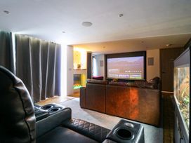 A home theater with a projector and seating area at Manor Farm House Merton near Bicester