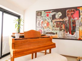 A music room with a piano and wall art at Manor Farm House in Merton near Bicester