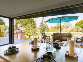 A dining area with a table and candles overlooking an outdoor space at Manor Farm House in Merton near Bicester