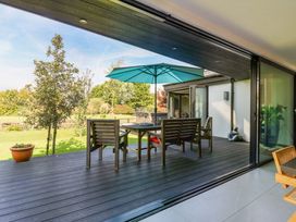 An outdoor area with a table and chairs under an umbrella at Manor Farm House in Merton near Bicester