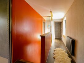 A hallway with an orange wall and sheepskin rug at Manor Farm House in Merton near Bicester