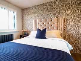 A bedroom with a bed and decorative headboard at Manor Farm House in Merton near Bicester