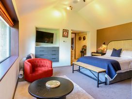 A bedroom with a bed, armchair, and TV at Manor Farm House in Merton near Bicester