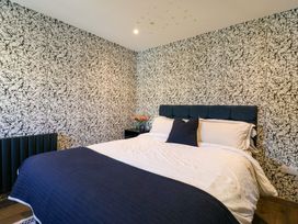 A bedroom with a bed and flowers on a side table at Manor Farm House in Merton near Bicester