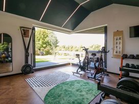 A gym with exercise equipment and a view at Manor Farm House in Merton near Bicester