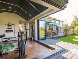 A gym with exercise equipment and an outdoor deck area at Manor Farm House in Merton near Bicester