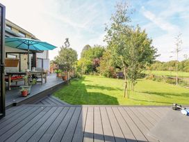 A garden with decking, table, and chairs at Manor Farm House in Merton near Bicester
