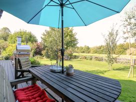 A garden with a table, benches and grill at Manor Farm House in Merton near Bicester