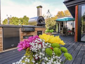 An outdoor dining area with flowers and an oven at Manor Farm House in Merton near Bicester