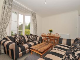 A living room with a sofa and a dining table at Violet's Rest in Exeter