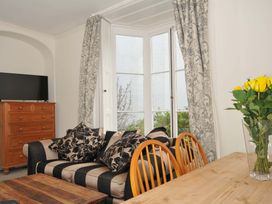 A living room with a sofa and television at Violet's Rest in Exeter