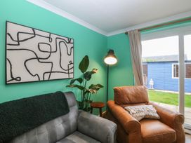 A living room with a sofa and an armchair at 61 Lloyd Street West in Llandudno
