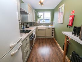 A kitchen with a sink and refrigerator at 61 Lloyd Street West Llandudno