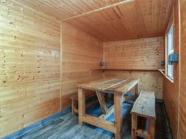A snug with wooden table and benches at 61 Lloyd Street West in Llandudno