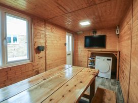 A snug with a table and television at 61 Lloyd Street West Llandudno