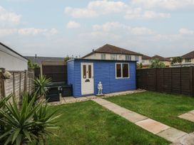 A garden with a blue shed and pathway at 61 Lloyd Street West in Llandudno