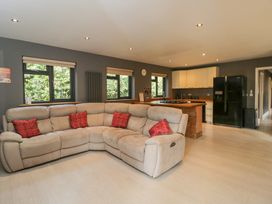 A living room with a sofa and kitchen area at Willow Cottage in Whiteparish