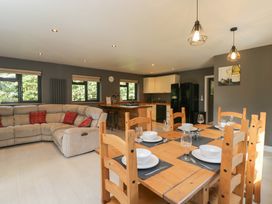 A dining room with a large table and sofa at Willow Cottage in Whiteparish