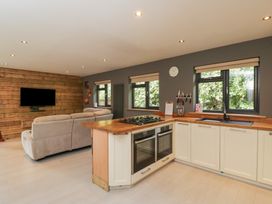 A kitchen with a stove and sofa at Willow Cottage in Whiteparish